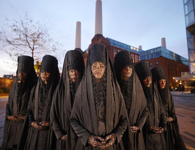 a group of people wearing black lace covering their faces
