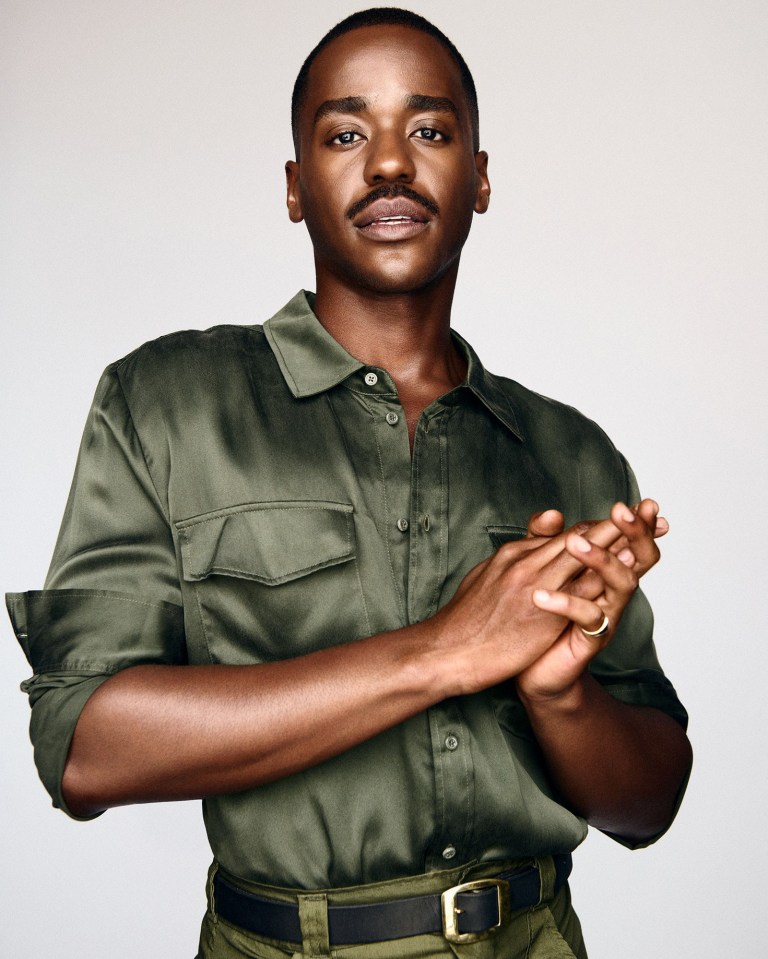 a man in a green shirt with his hands folded