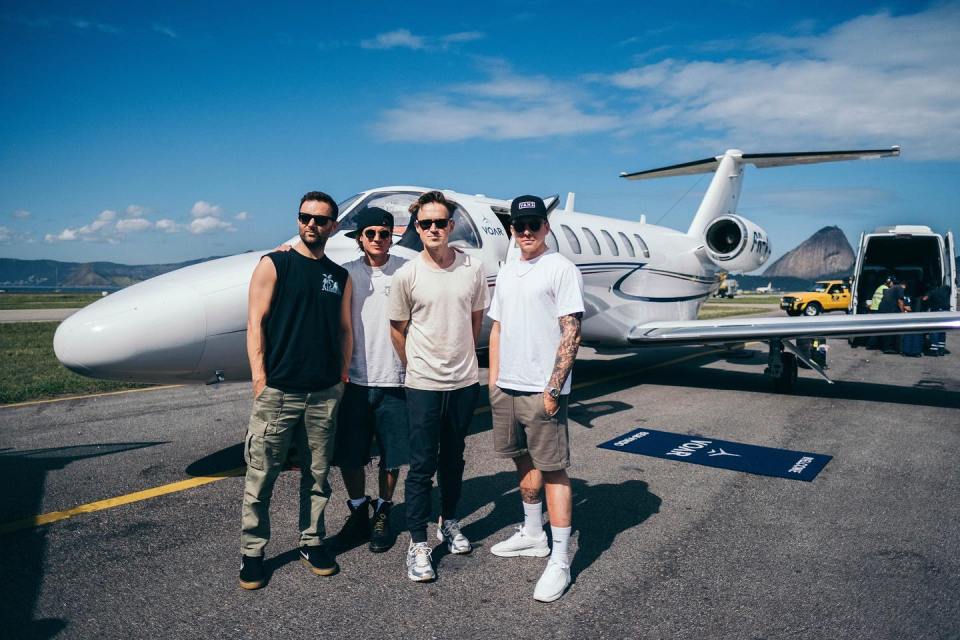 a group of men standing in front of a plane with the letters nsn on it