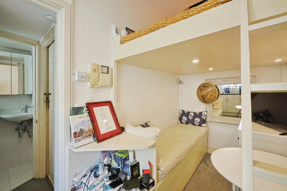 A 100-square-foot London flat with a built-in bed, small kitchen, and bathroom.