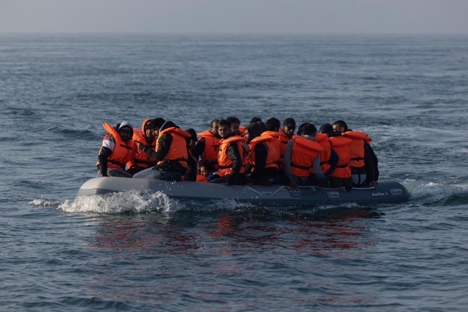Migrants in a small inflatable boat cross the English Channel.