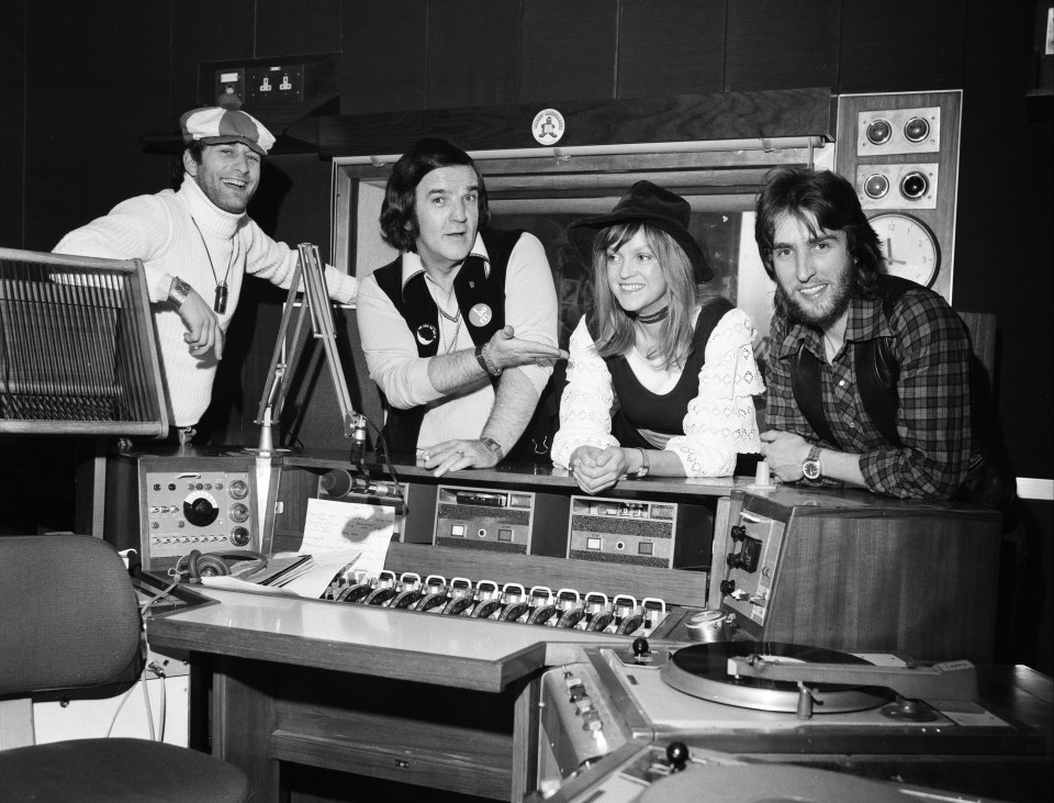 Four BBC disc jockeys in a recording studio.