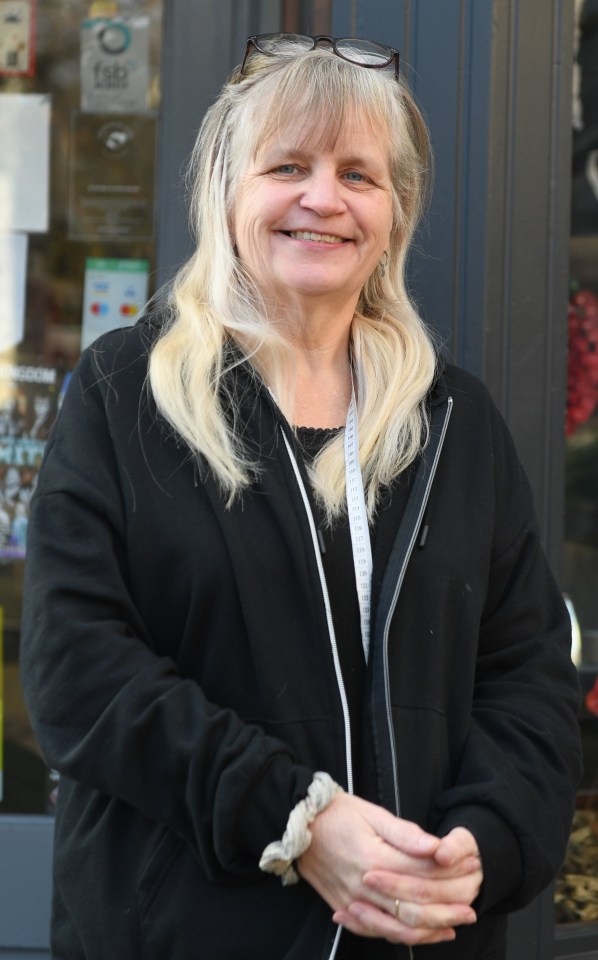 Woman standing outside her shop in Blaenau Gwent, UK, area with low life expectancy for women.