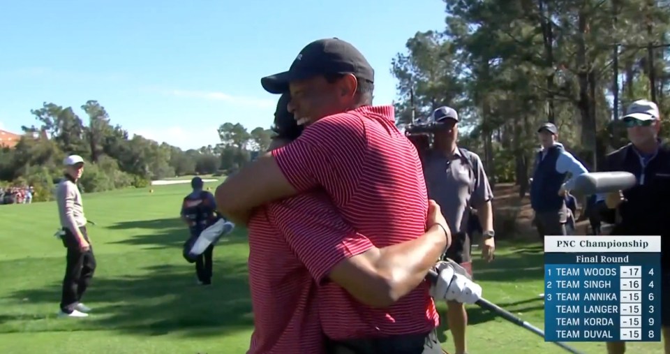Tiger Woods hugging his son after a golf tournament.