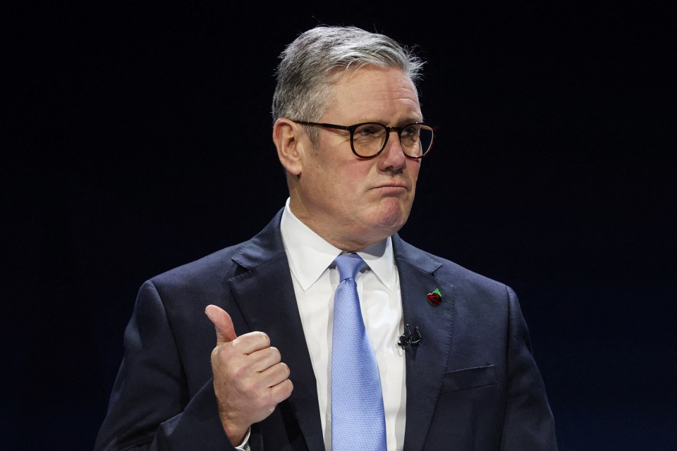 Keir Starmer giving a thumbs-up during a speech.