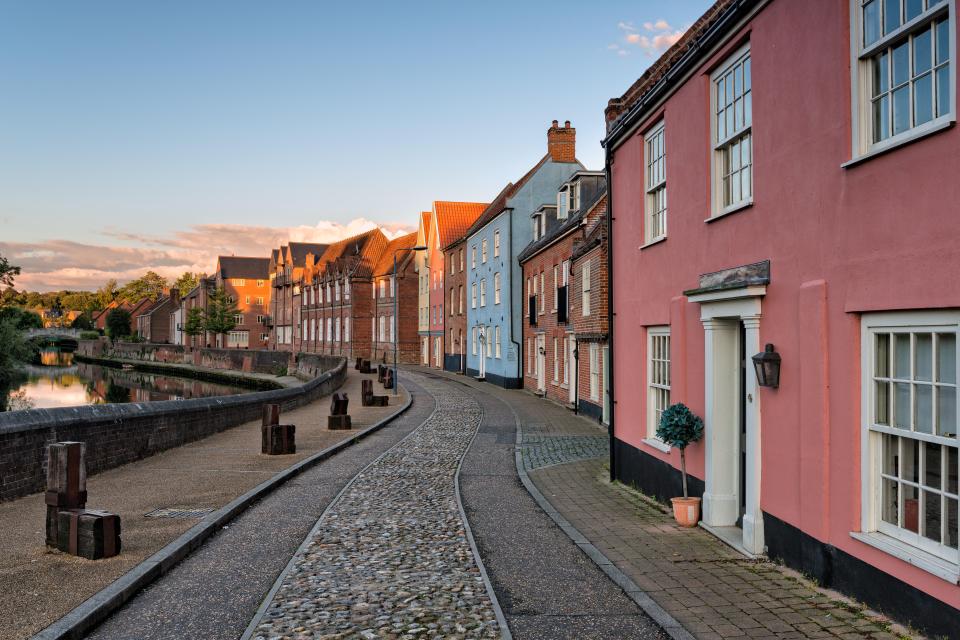 Cobblestone street alongside a river in Norwich, England.
