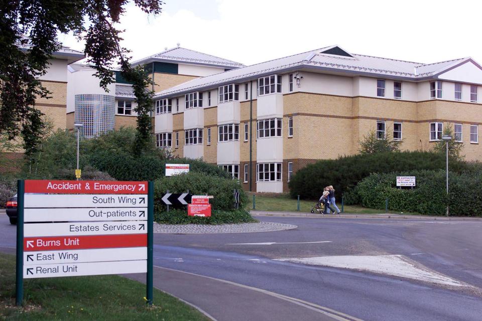 Broomfield Hospital exterior with directional signage indicating Accident & Emergency, South Wing, Out-patients, Estates Services, Burns Unit, East Wing, and Renal Unit.