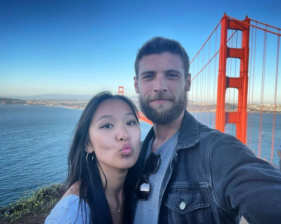 Ned Porteous and a woman pose for a selfie at the Golden Gate Bridge.