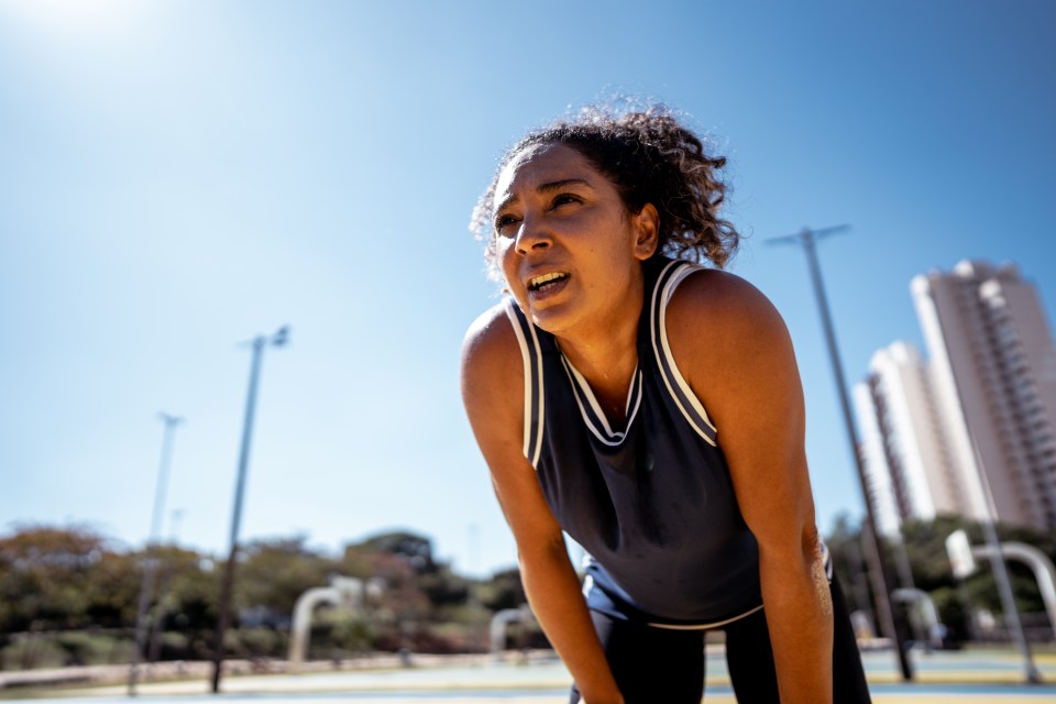 A sweaty woman rests after exercising outdoors.