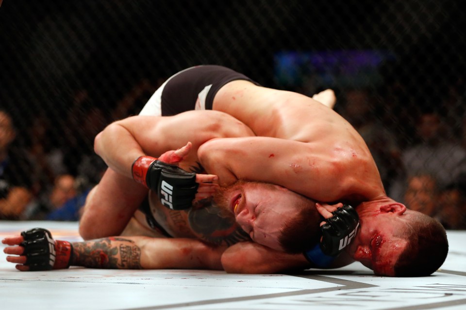 Nate Diaz attempting a submission hold on Conor McGregor during a UFC welterweight bout.