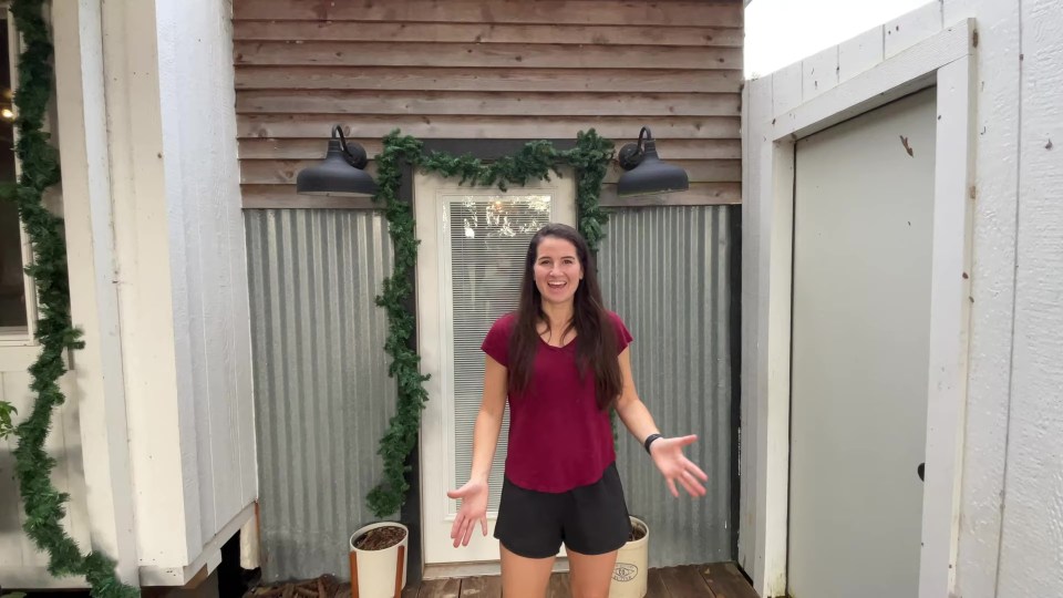 Woman standing in front of her mortgage-free home.