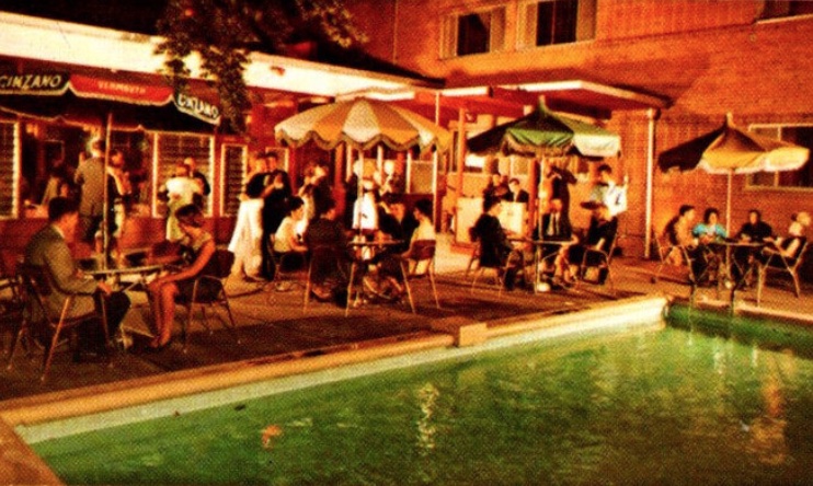 Nighttime photo of people socializing around a pool at the Treadway Inn in Niagara Falls, New York.