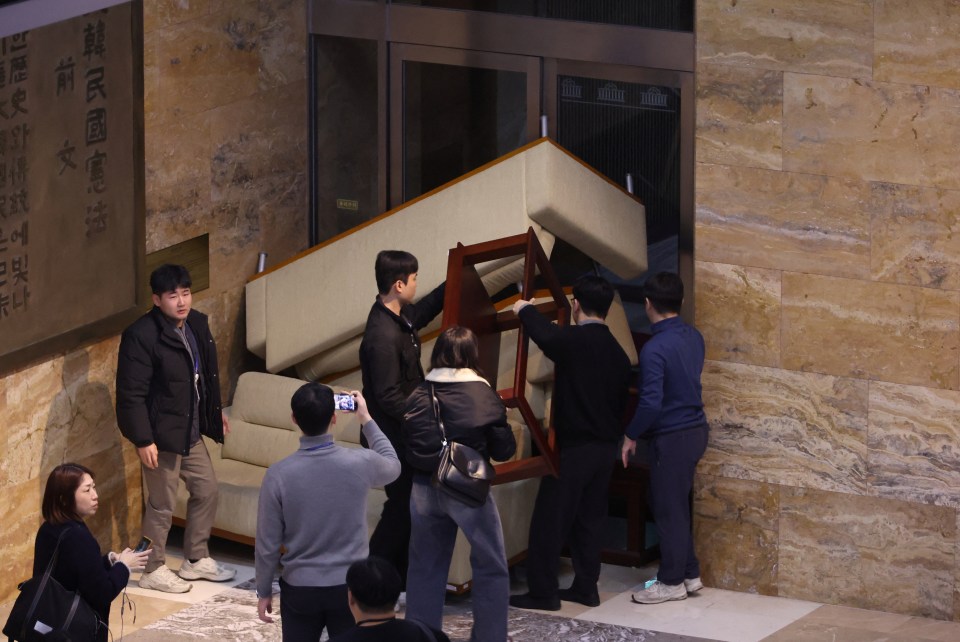 South Korean opposition party staff barricade the National Assembly with furniture.