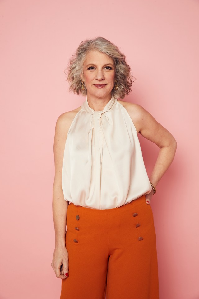 Portrait of Stephanie Chilvers wearing a white top and orange pants.