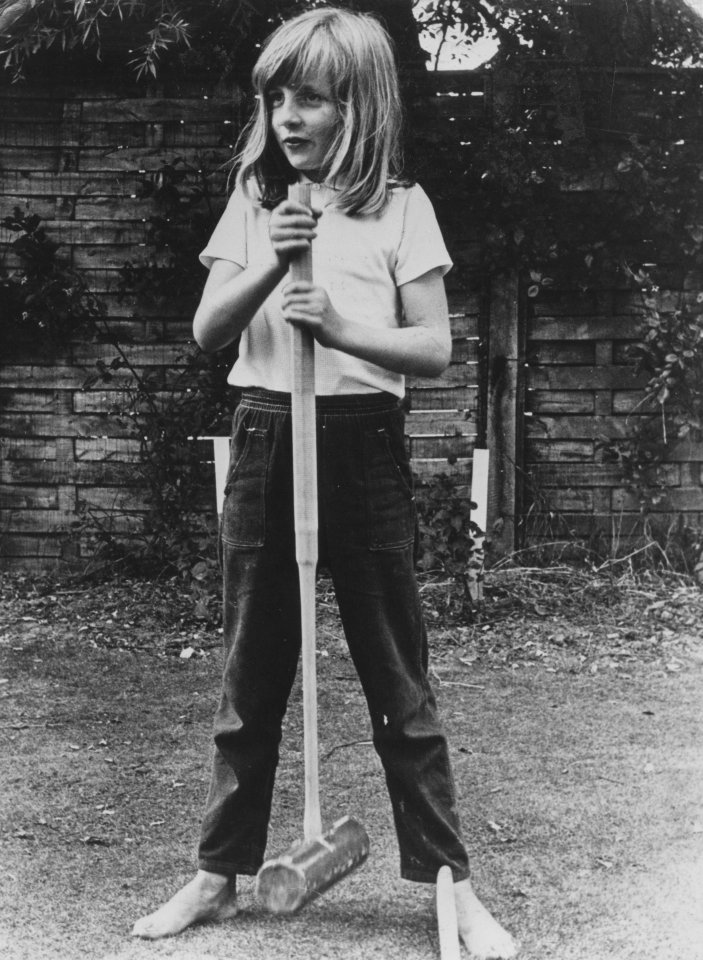 Black and white photo of a young Diana Spencer playing croquet.