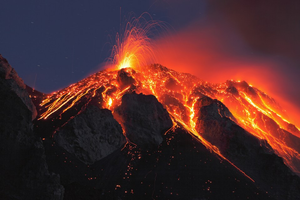 Lava flows down a volcano at night.