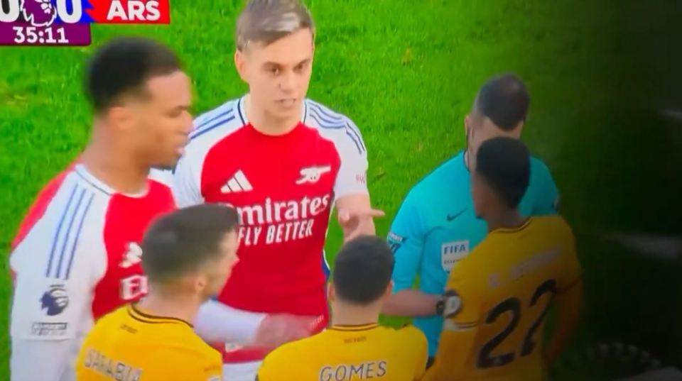Soccer players arguing with a referee.
