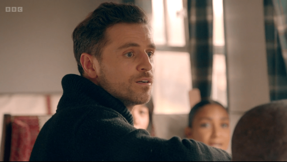 Screenshot of a man speaking to a group of people.