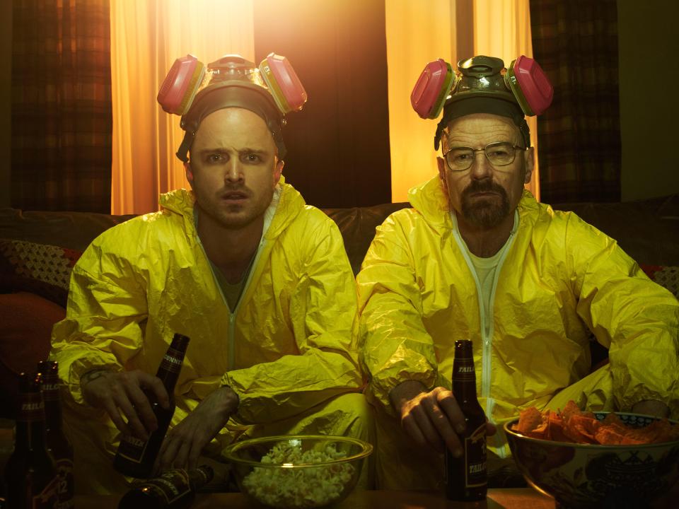 Jesse Pinkman and Walter White in hazmat suits watching TV.