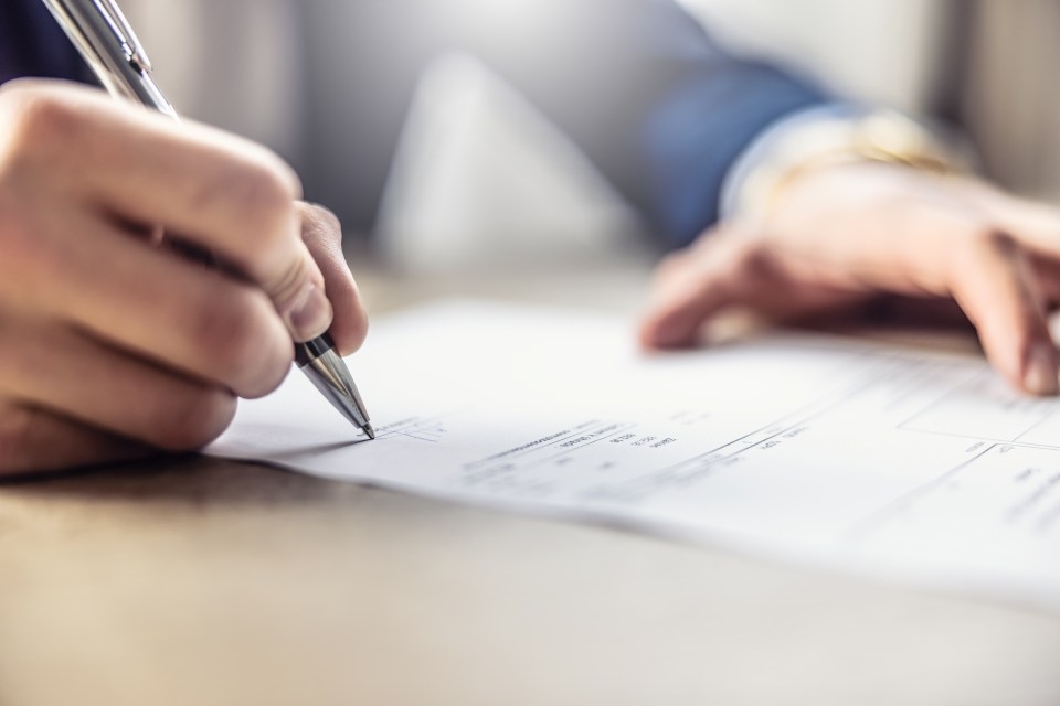 Close-up of a person signing a document.