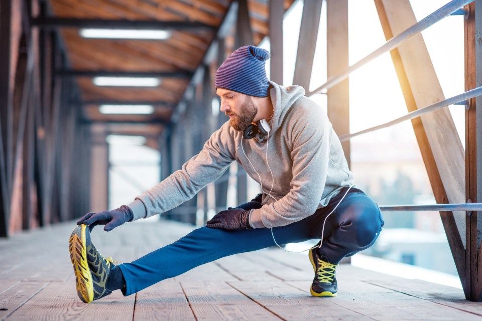 Man stretching on a bridge.