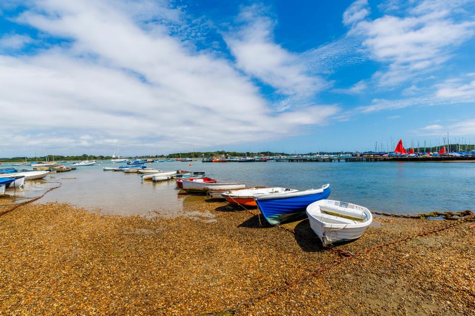 Rowing boats moored on a pebbled shoreline.