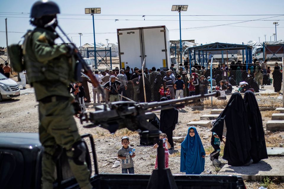 Kurdish security forces guard released detainees leaving a camp for relatives of suspected Islamic State fighters in Syria.