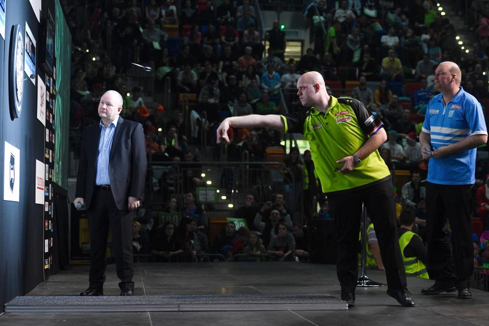 Michael van Gerwen throwing a dart at a darts board.