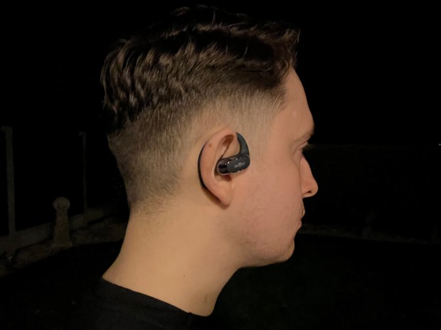 Person wearing Shokz OpenFit Air earbuds.