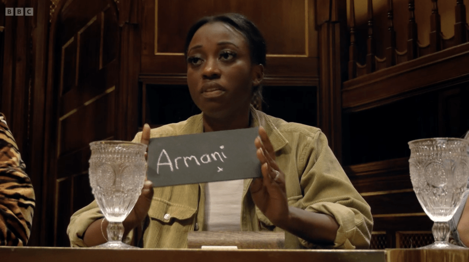A Traitors contestant reveals a slate with "Armani" written on it.