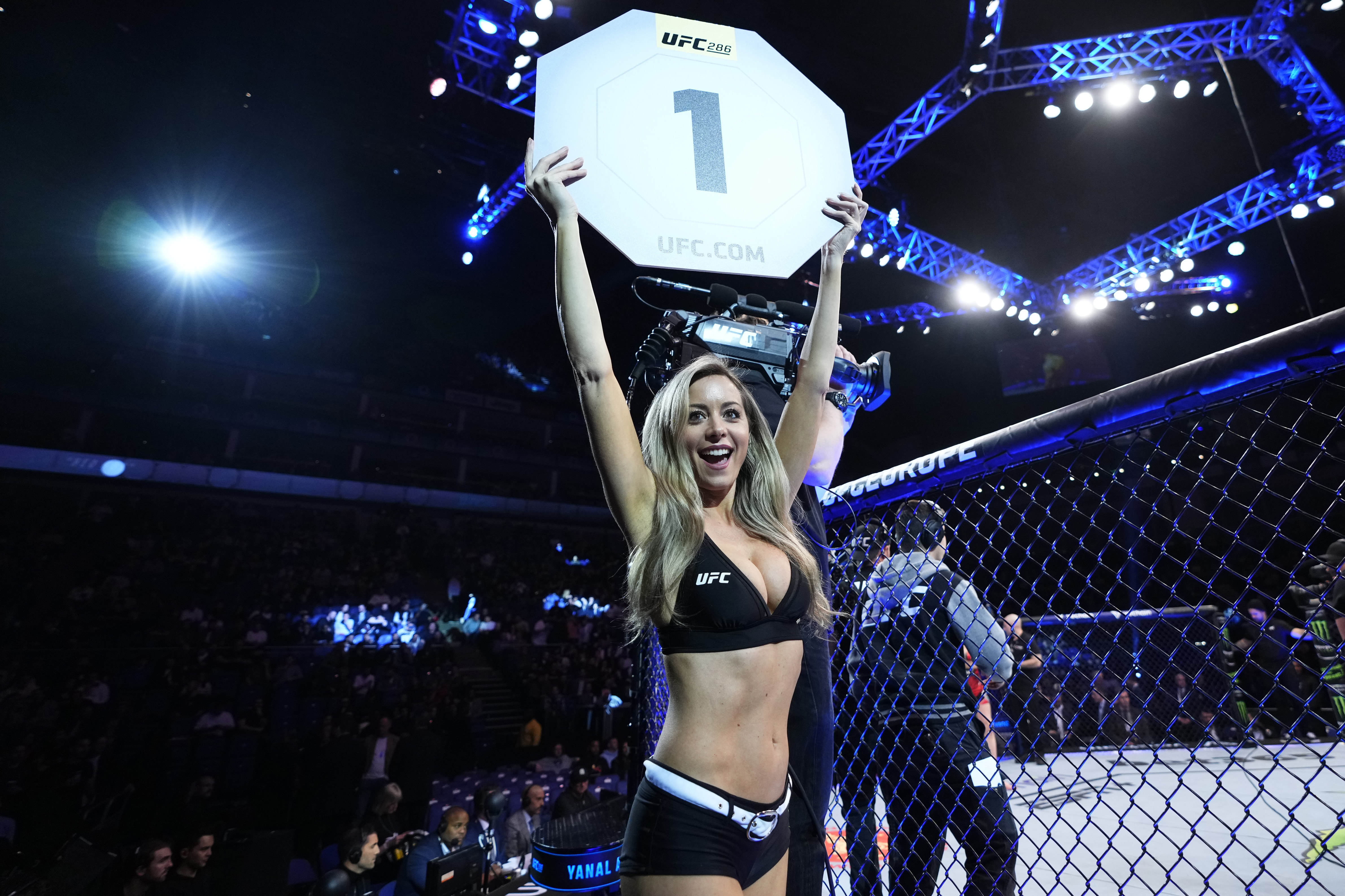 UFC Octagon Girl Carly Baker holding a round 1 sign.