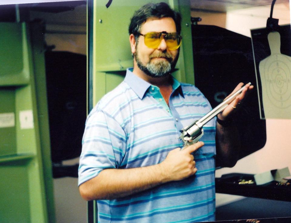 Man holding a revolver at a shooting range.
