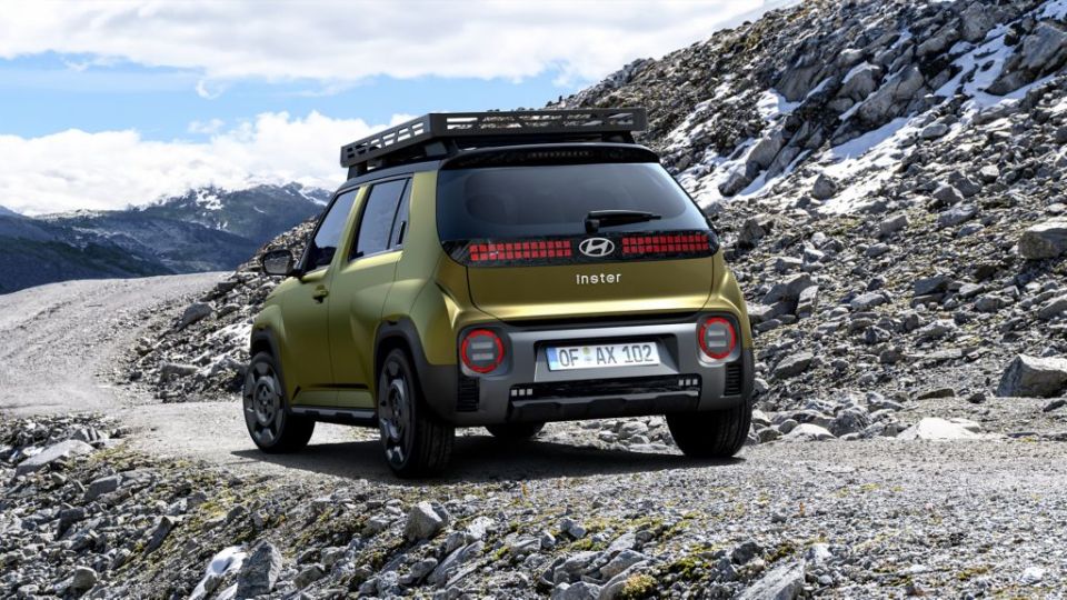 Rear view of a Hyundai Inster Cross electric city car on a rocky road.