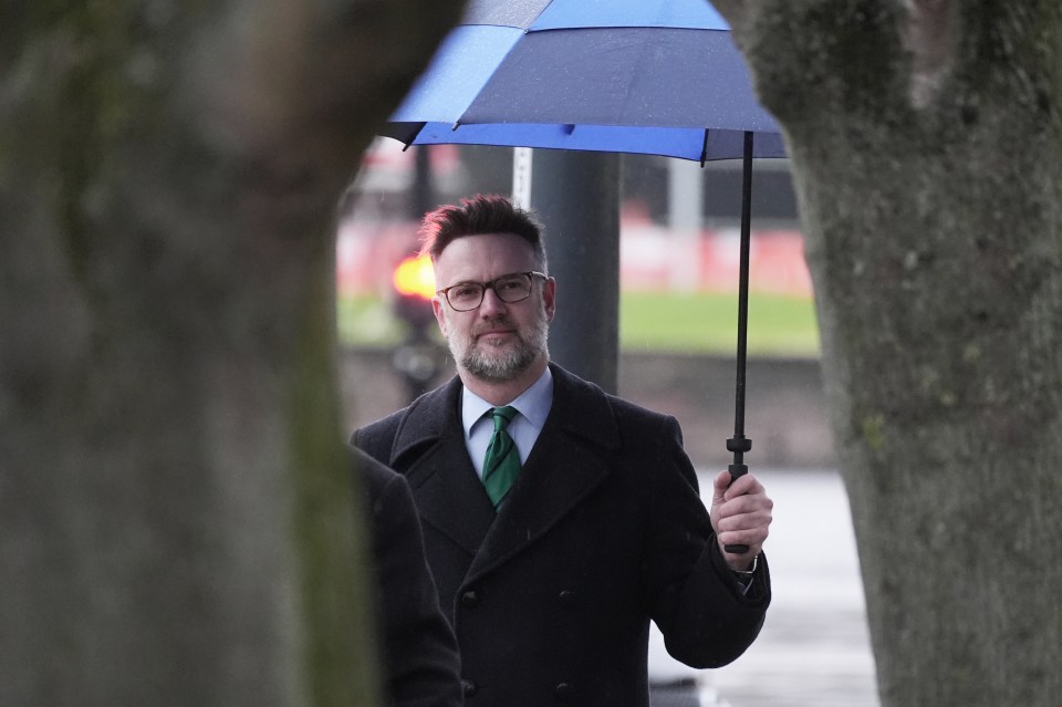 Charles Hanson arriving at Derby Crown Court under an umbrella.