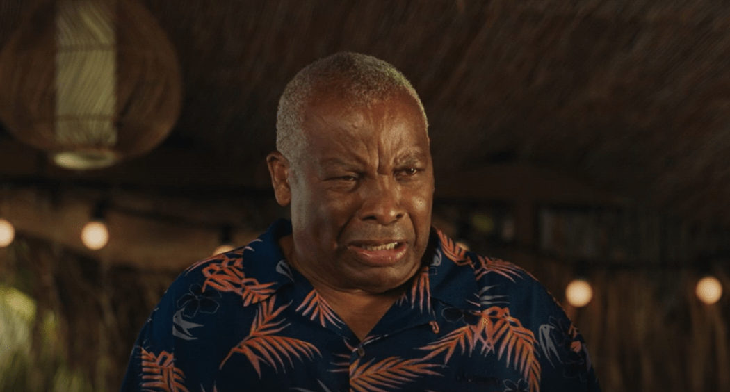 Older man with graying hair wearing a patterned shirt.