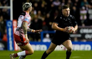 George Williams of Warrington Wolves running with the rugby ball during a match.