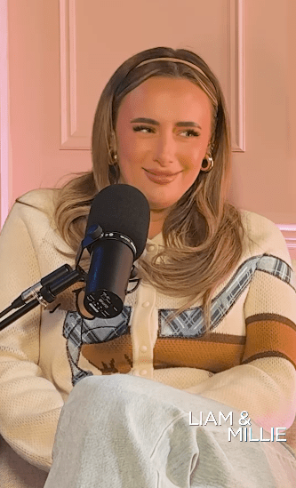 Woman smiling at microphone during podcast interview.