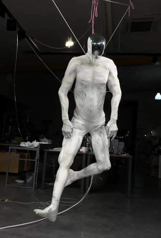 A white humanoid robot suspended in mid-air.