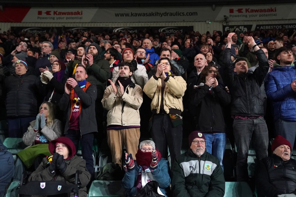Burnley football fans applauding in the stands.