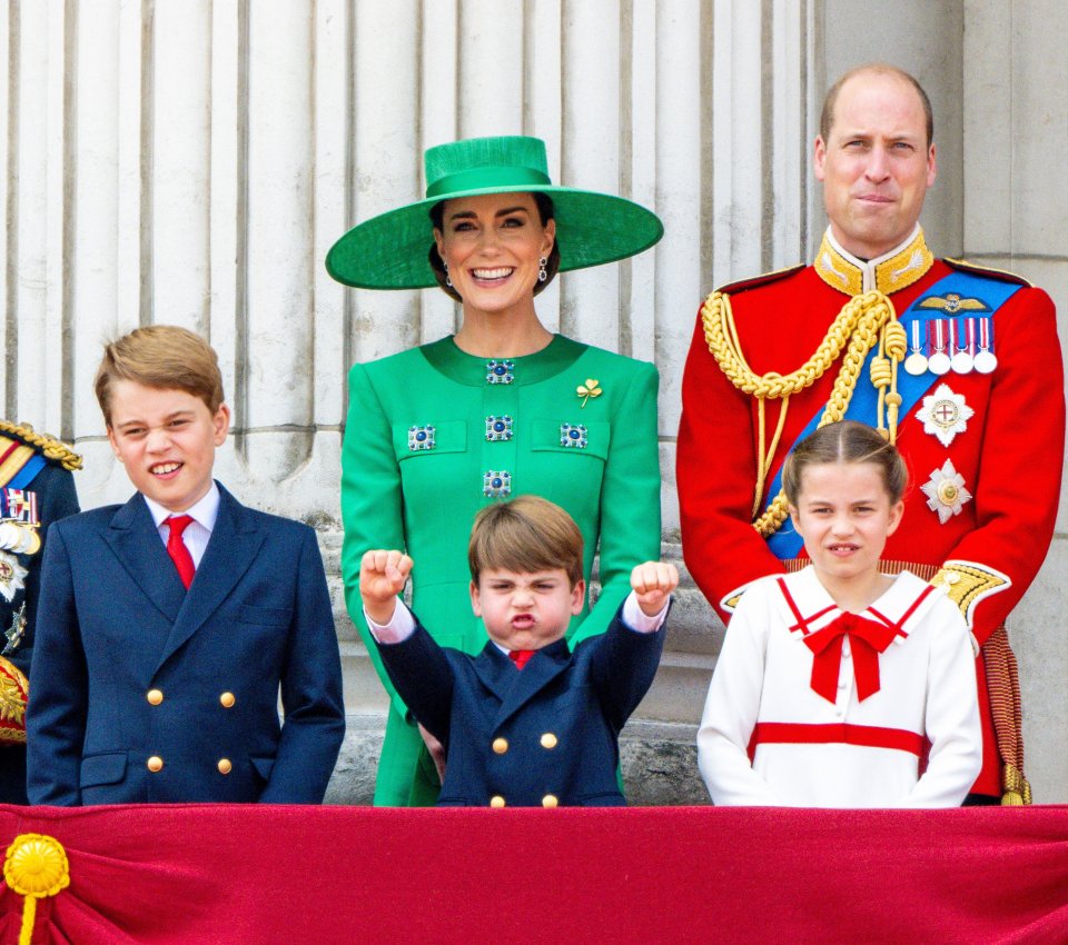 Catherine, Prince William, and their three children on a balcony.