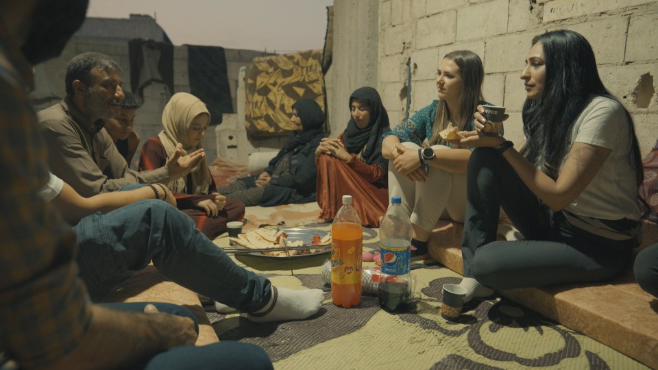 Chloe and Bushra sitting with their family in Raqqa, Syria.