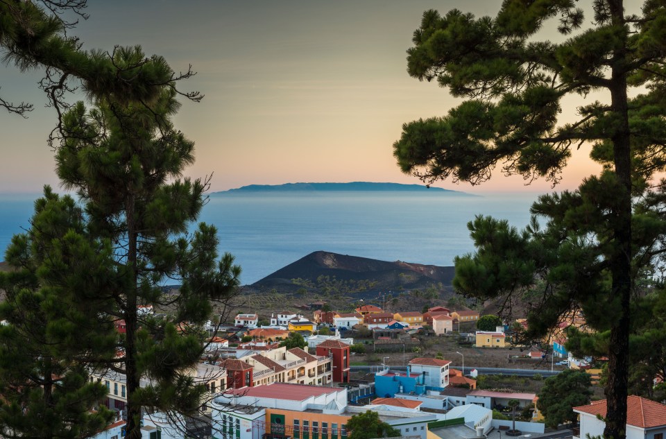 Sunset view of Los Canarios town, La Palma, with El Hierro island in the background.