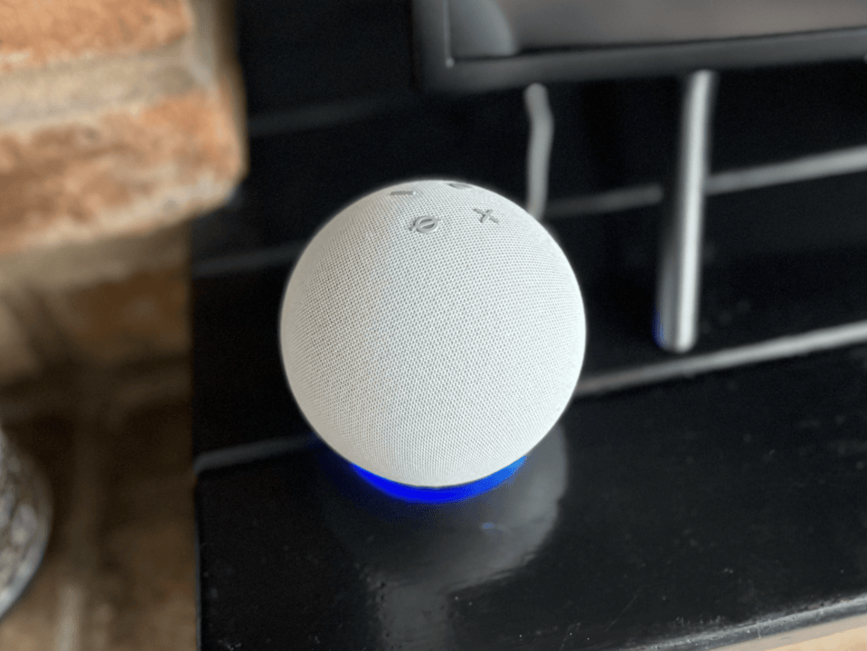 White Echo Dot smart speaker with blue light.