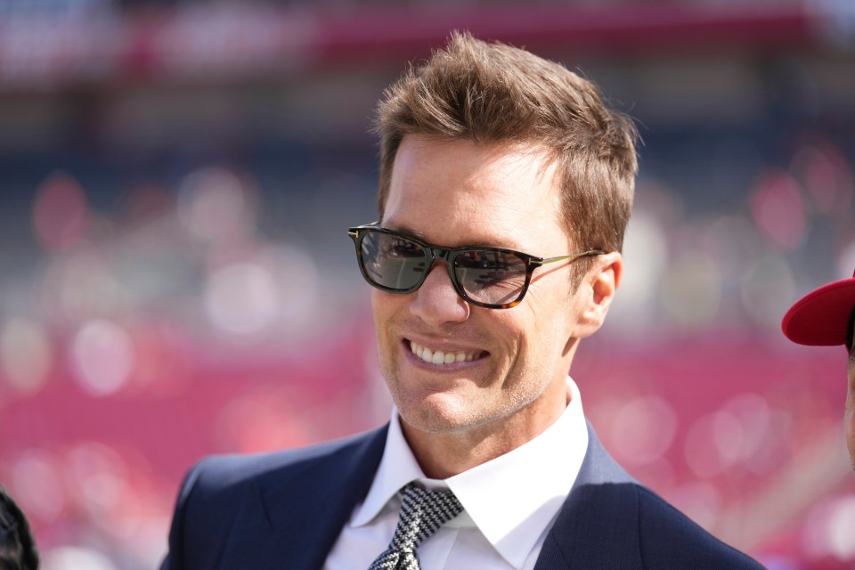 Tom Brady smiling and wearing sunglasses.