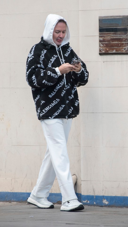 Person in Balenciaga jacket using a phone.