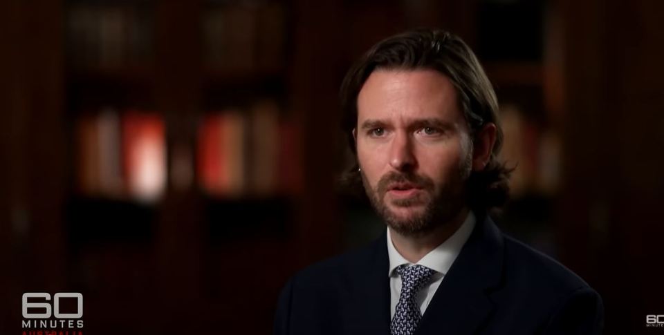 A man in a suit speaks during an interview.