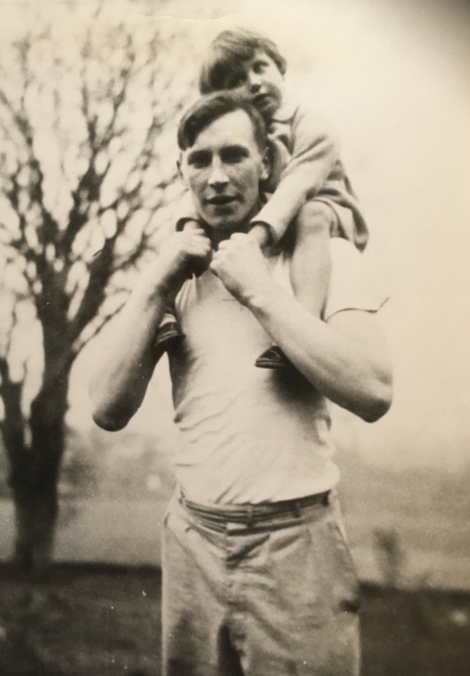 Black and white photo of Paddy Mayne with a child on his shoulders.