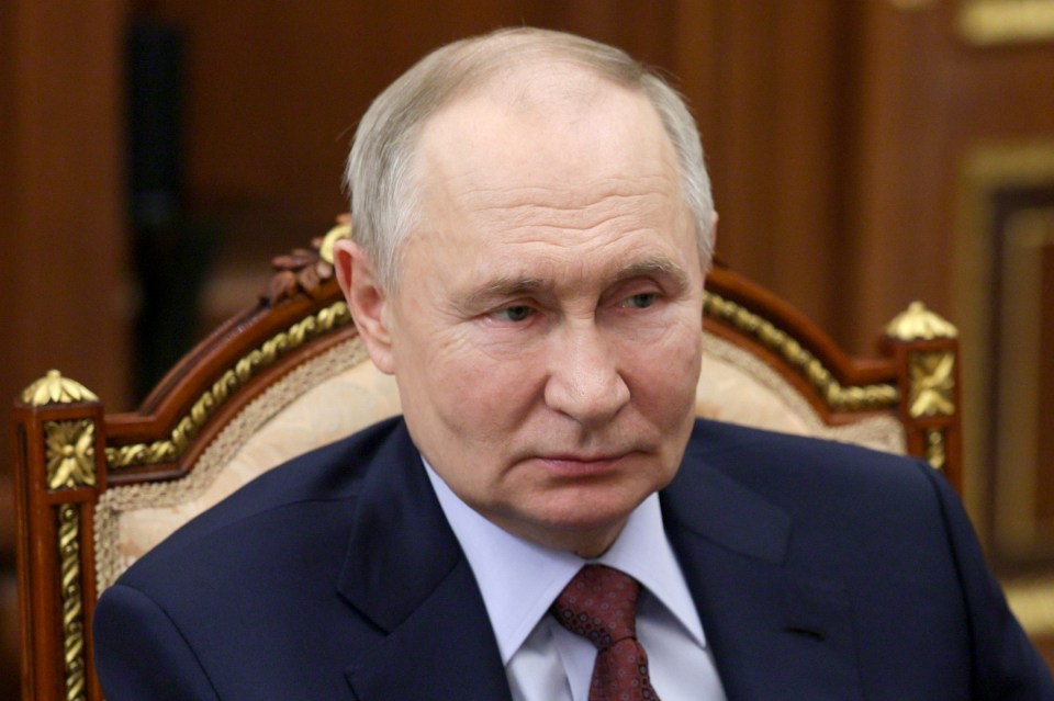 Vladimir Putin listening during a meeting.