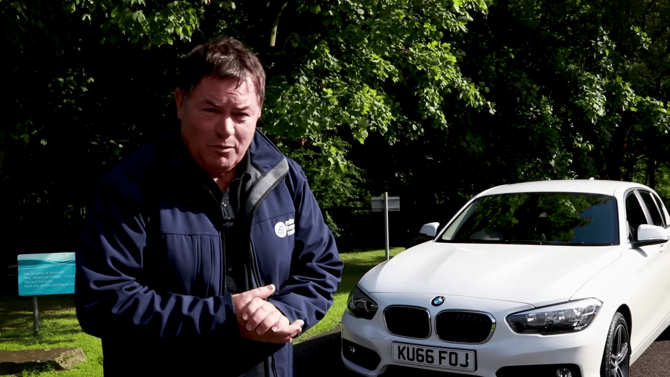 Mike Brewer standing next to a white BMW.