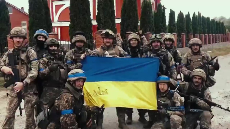 Ukrainian soldiers holding their national flag.